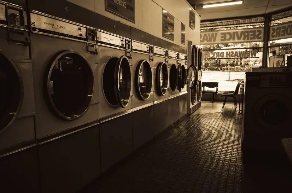 Sepia-toned image of a laundromat interior showcasing a row of classic washing machines.